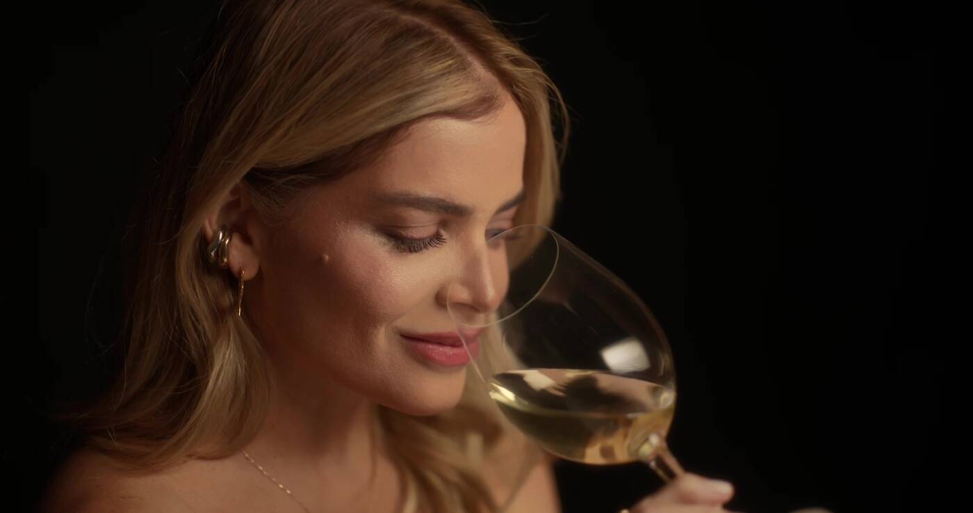 Aneley oliendo una copa de vino blanco